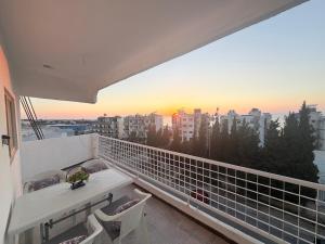 a balcony with a table and chairs and a sunset at Neue renovierte Wohnung mit Meerblick und große Balkon in tripoli ,Qalamoun in El Qalmoûn