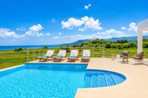 a swimming pool with lounge chairs and a swimming pool at Villa Pinelopi Tria in Kounopetra