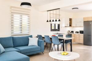 a living room with a blue couch and a table at Villa Pinelopi Tria in Kounopetra