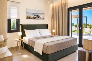 a bedroom with a bed and a view of the ocean at Villa Pinelopi Tria in Kounopetra
