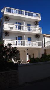 Biały budynek z balkonami na boku w obiekcie Guesthouse Ana-Maria w mieście Pirovac