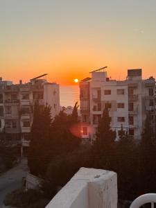 a sunset over a city with buildings and the ocean at Neue renovierte Wohnung mit Meerblick und große Balkon in tripoli ,Qalamoun in El Qalmoûn +3 photos