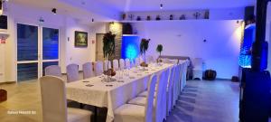 a white room with a long table with white chairs at CASA ARYAN in Sînpetru