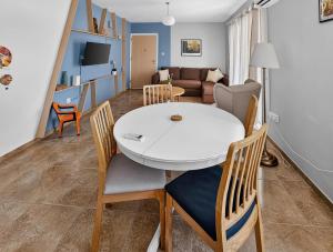 a dining room and living room with a white table and chairs at Rest Studio 6 in Sotira +7 photos