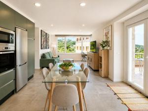 a kitchen and living room with a glass table and chairs at Holibai Portaliña, Mar y Montaña, Baiona in Baiona