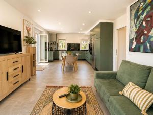 a living room with a green couch and a table at Holibai Portaliña, Mar y Montaña, Baiona in Baiona