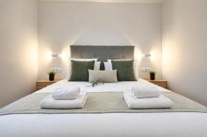 a large white bed with two white towels on it at Holibai Portaliña, Mar y Montaña, Baiona in Baiona