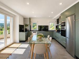 a kitchen with a glass table with chairs and appliances at Holibai Portaliña, Mar y Montaña, Baiona in Baiona +8 photos