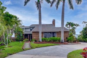 a house with palm trees and a driveway at Pet Friendly! Canal-Front Apollo Beach Gem w/ Pool in Apollo Beach