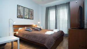 a bedroom with a bed with towels on it at Apartamenty Sedinum - Modern in Szczecin