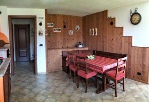a dining room with a red table and chairs at La Betulla in Oyace