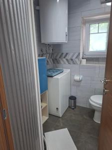a small bathroom with a toilet and a window at Kameni biser in Jurdani +83 photos