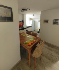 a kitchen and dining room with a wooden table and chairs at Plate lyn atostogų būstas in Plateliai
