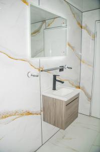 a bathroom with a sink and a mirror at Macao Sky pool suites in Punta Cana +24 photos