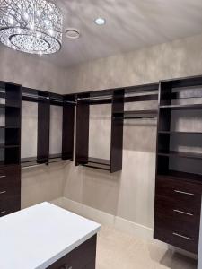 a kitchen with dark wood cabinets and a chandelier at Mariposa Cozy Stay in Richmond