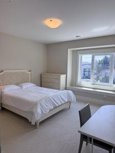 a bedroom with a bed and a table and a window at Mariposa Cozy Stay in Richmond