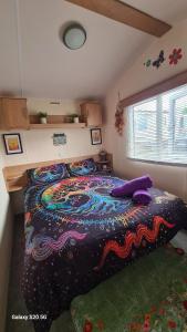 a bedroom with a large bed with a colorful blanket at Meadows nook in Clitheroe