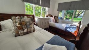 a bedroom with two beds and two windows at The Ark Holiday Home in Stanford