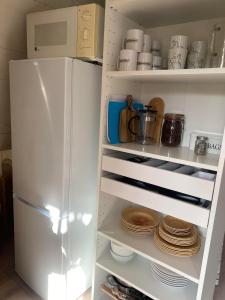 a white refrigerator with plates and dishes in it at Rialahästgård in Uddeby
