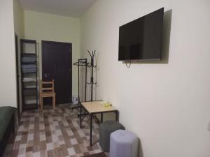 a living room with a flat screen tv on a wall at Ani Center Hotel in Dovekh