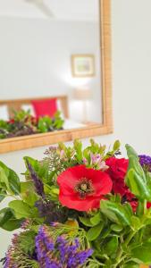 a bouquet of flowers in front of a mirror at Cruise Cottage in Stanford +47 photos