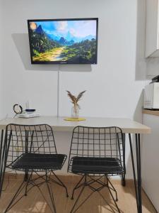 a table with two chairs and a tv on the wall at Friends Home in Tirana