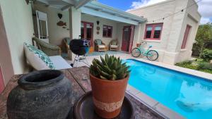 a house with a plant on a table next to a pool at Bramber cottage Stay a while in Stanford