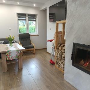 a living room with a fireplace and a table and a chair at Dom w górach Przy szlaku in Bystra