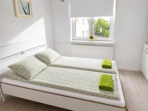 a white bedroom with a bed and a window at Pokoje nad Welem Lidzbark in Lidzbark