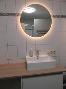 a bathroom with a white sink and a mirror at Gite du Circuit in Stavelot +8 photos