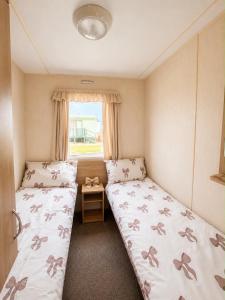 two beds in a small room with a window at 7 Jay Valley in Bridlington +15 photos