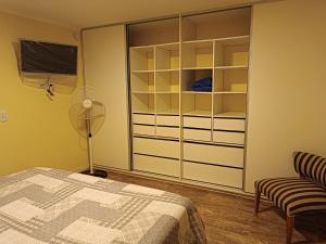a bedroom with a closet and a bed and a fan at Melo 2203 Duplex 1 in Belén de Escobar