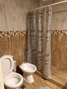 a bathroom with a toilet and a shower curtain at Melo 2203 Duplex 1 in Belén de Escobar +24 photos