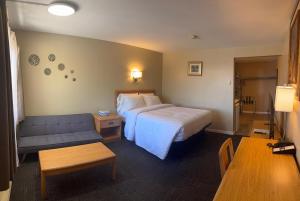 a hotel room with a bed and a couch at Hawberry Motel in Little Current