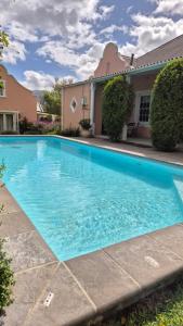 a large blue swimming pool in front of a house at Stanford Villa in Stanford