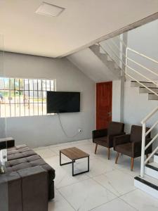 a living room with a couch and a tv at Pousada Ômega in Caxias das Aldeias Altas