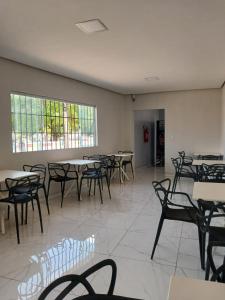 a dining room with tables and chairs and windows at Pousada Ômega in Caxias das Aldeias Altas