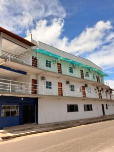 a white building with balconies on the side of a street at Pousada Ômega in Caxias das Aldeias Altas