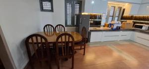 a kitchen with a wooden table and four chairs at Square Accommodation Rudra kunj in Pokhara +3 photos