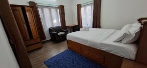 a bedroom with a bed and a chair in it at Square Accommodation Rudra kunj in Pokhara