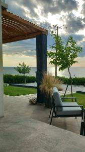 a chair on a patio with a view of the ocean at Saos Terra Suites in Samothraki