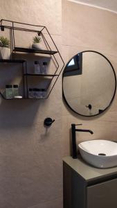 a bathroom with a round mirror and a sink at Saos Terra Suites in Samothraki +51 photos