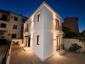 a white building with lights on the side of it at ODA Central Stay in Elbasan