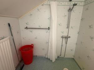 a bathroom with a shower curtain and a trash can at Apartment Målargården in Uddeholm +15 photos