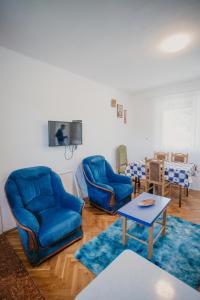 ein Wohnzimmer mit zwei blauen Sesseln und einem Tisch in der Unterkunft Vikendica Nik in Bogutovac