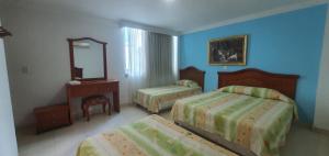 a hotel room with two beds and a mirror at HOTEL VASCONIa in Cúcuta