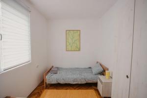 ein Schlafzimmer mit einem Bett in einer weißen Wand in der Unterkunft Vikendica Nik in Bogutovac