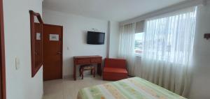 a bedroom with a bed and a chair and a window at HOTEL VASCONIa in Cúcuta +9 photos