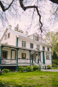 a large white house with a green trim at Triangle de l'île Chambre le Grenier in Saint-Laurent-de-l'ile d'Orleans