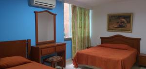 a bedroom with two beds and a mirror and a window at HOTEL VASCONIa in Cúcuta